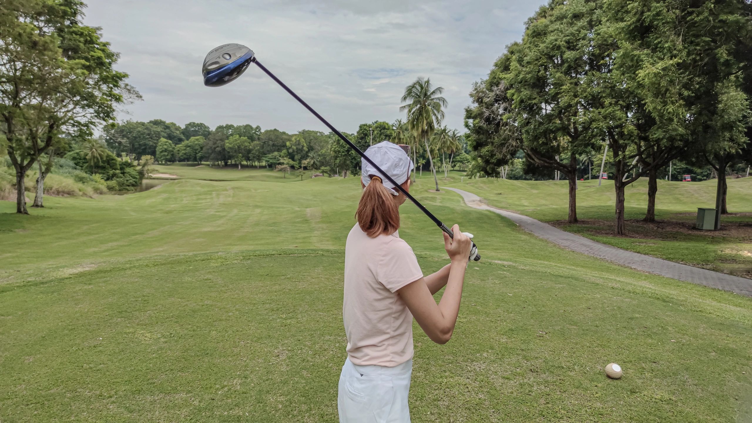 Golfer teeing off on a golf course